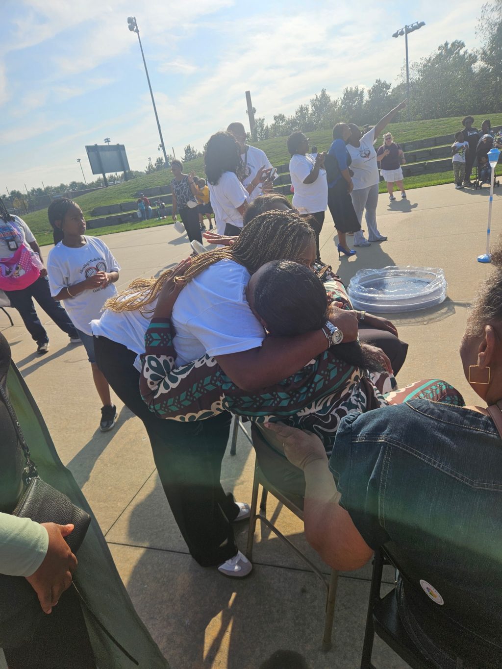 Community members embracing at the Mending Minds & Hearts balloon release