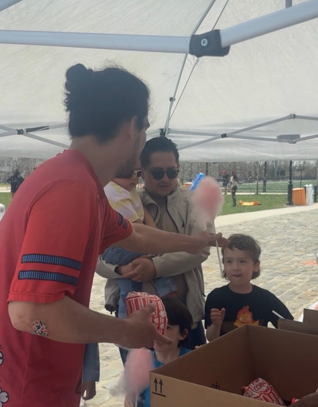 Volunteers handing out cotton candy under the tent