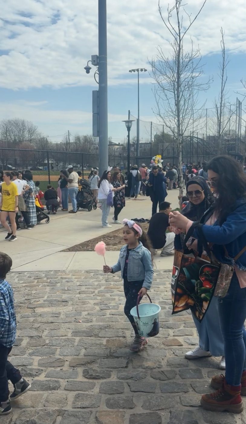 A child with a basket and cotton candy at the egg hunt