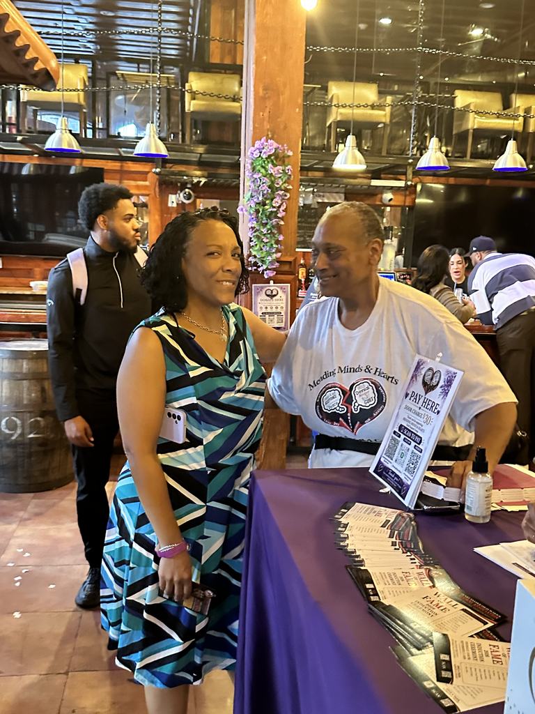 A volunteer welcoming a guest at the check-in table