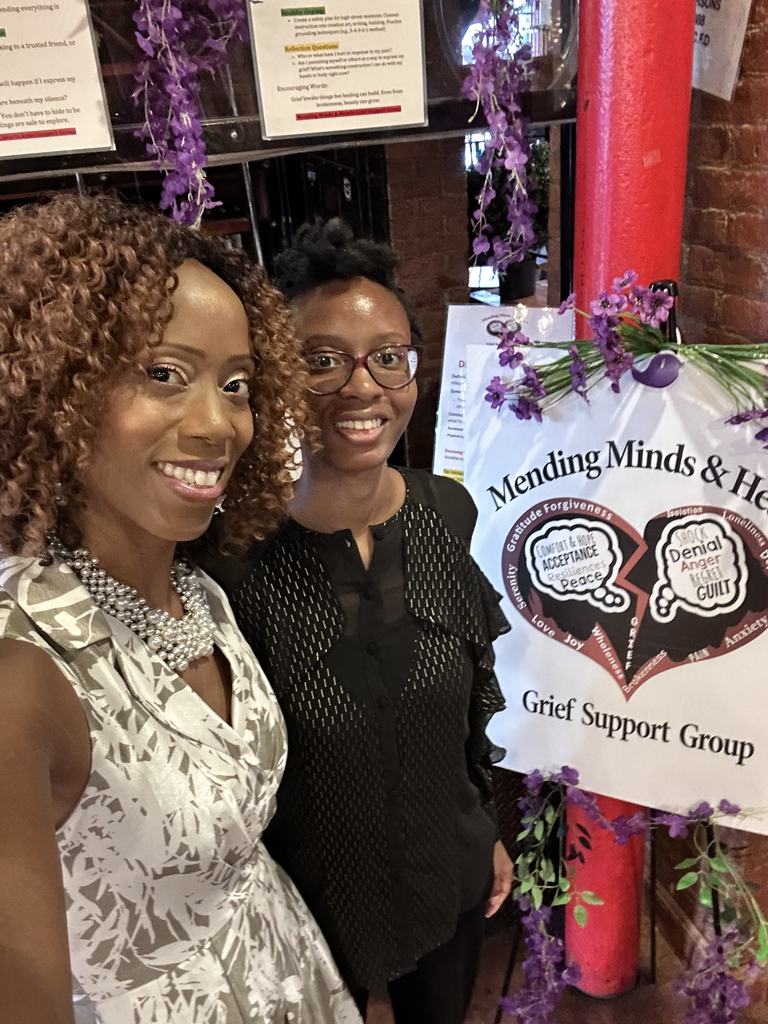 Two supporters beside the Mending Minds and Hearts banner at the fundraiser