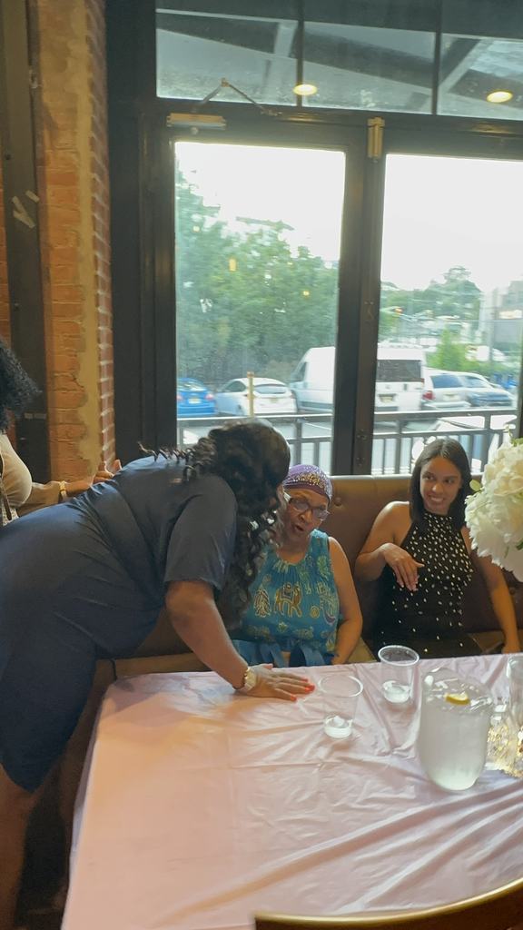 The founder leaning in to greet guests at their table