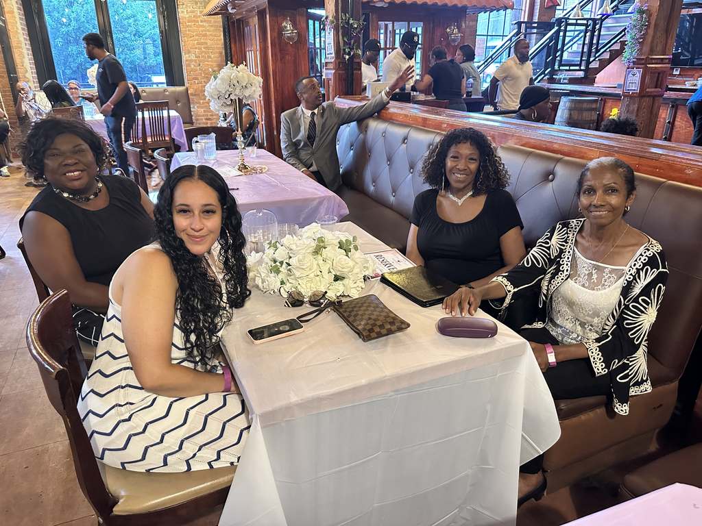 Four guests seated at a table with white roses at the fundraiser