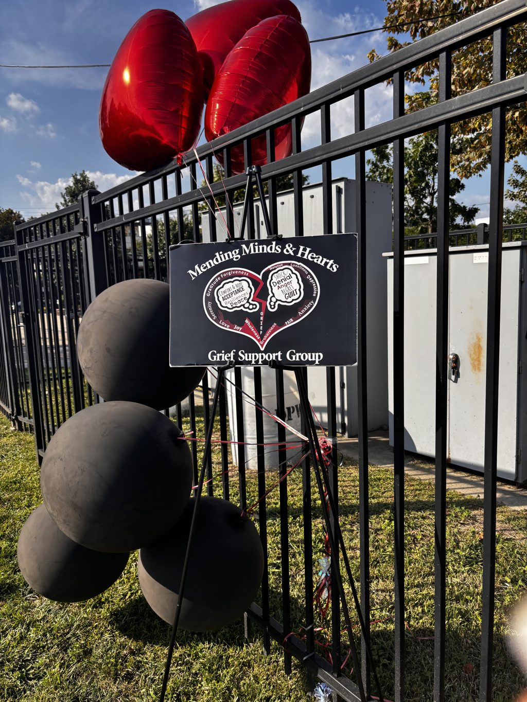 Mending Minds & Hearts Grief Support Group sign with red heart balloons at National Night