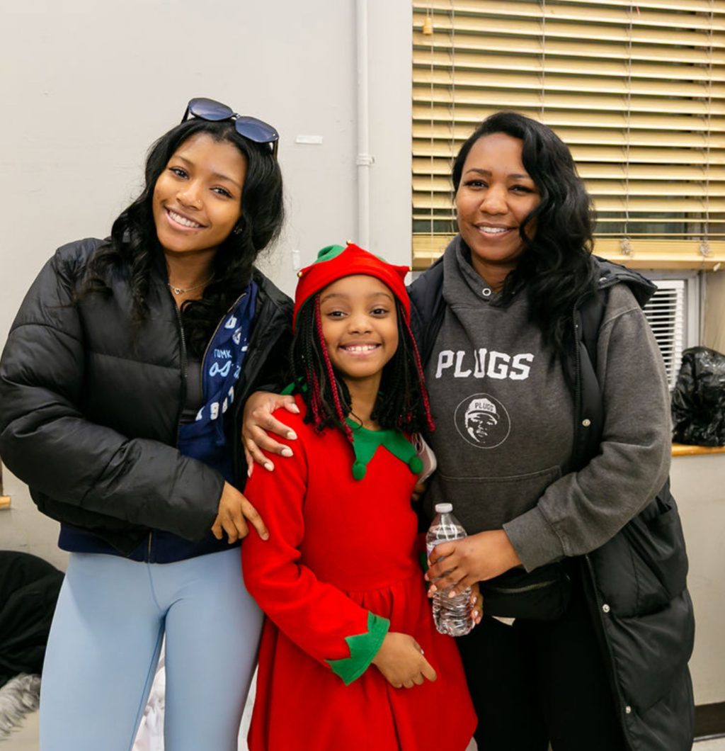 Smiling family at the Mending Minds and Hearts toy drive