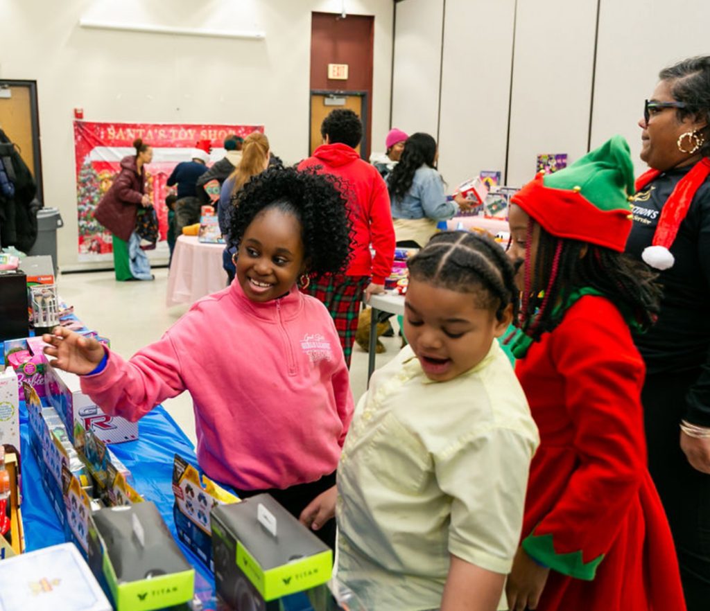 Children choosing gifts at the Santa's Toy Shop tables