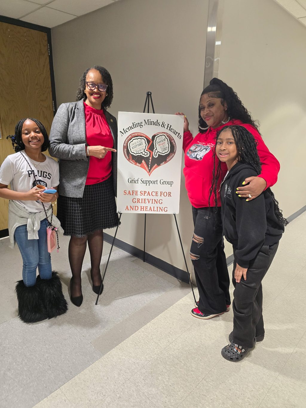 Guests beside the Mending Minds and Hearts safe space for grieving and healing sign